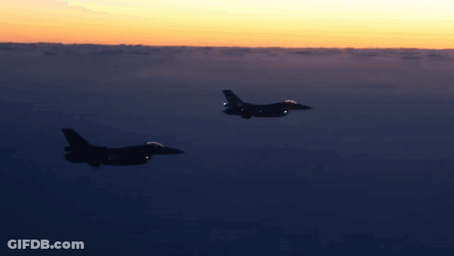 Two Fighter Jets Flying At Sunset GIF