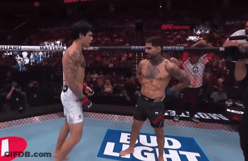 Two Fighters In A Boxing Ring With A Bud Light Advertisement On The Floor GIF