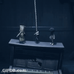 Two Figurines Standing On Piano In Dark Room GIF
