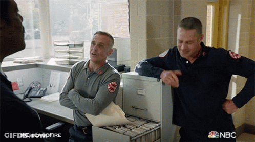 Two Firefighters In Front Of Filing Cabinet With NBC GIF