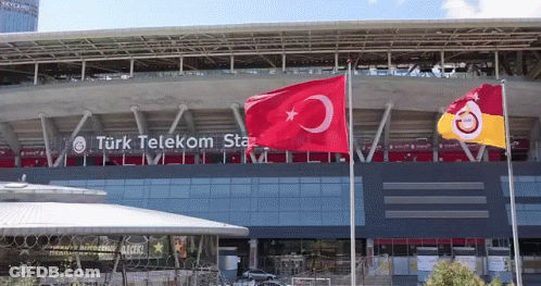 Two Flags Flying In Front Of Turk Telekom Building GIF