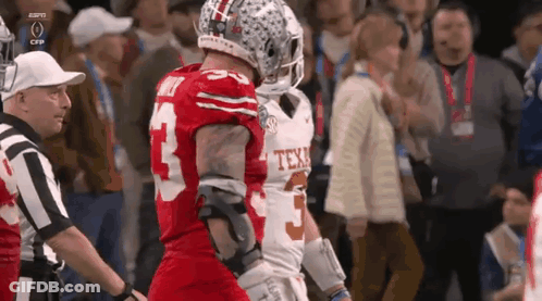 Two Football Players Are Standing Next To Each Other And One Has The Number 5 On His Jersey GIF