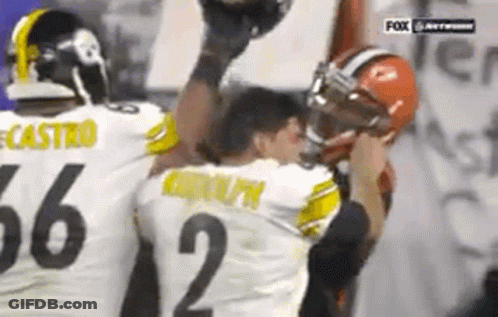 Two Football Players Are Standing Next To Each Other On A Field . GIF