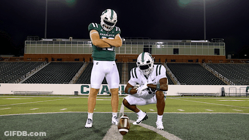 Two Football Players From The Charlotte Team Are Posing For A Picture GIF