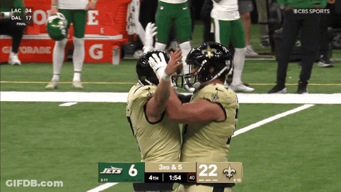 Two Football Players Hugging On Field With 3Rd & 5 Scoreboard GIF