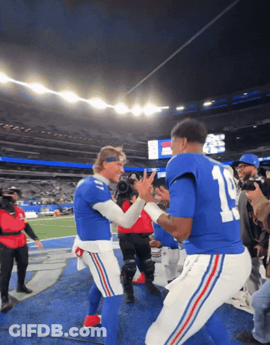 Two Football Players In Blue Uniforms With The Number 11 On The Back GIF