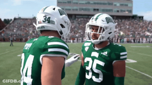 Two Football Players In Green And White Uniforms Numbers 34 And 35 GIF