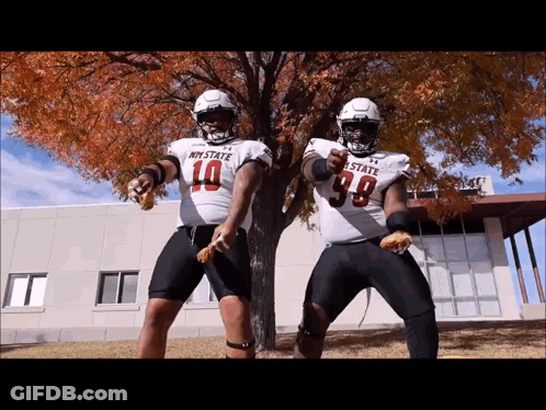 Two Football Players In My State Jerseys Dancing In Front Of Tree GIF