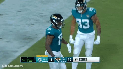 Two Football Players On Field With Scoreboard Saying Fis GIF