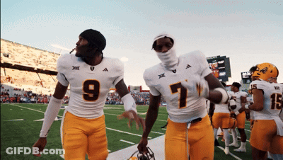 Two Football Players One Wearing Number 9 And The Other Wearing Number 7 Walk Off The Field GIF