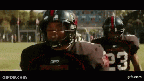 Two Football Players Wearing Helmets And Jerseys With The Number 23 On Them Are Walking On A Field . GIF