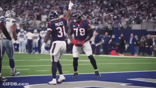 Two Football Players Wearing Jerseys With The Number 31 And 78 Are Celebrating On The Field . GIF