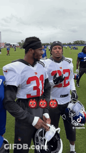 Two Football Players Wearing Jerseys With The Number 32 GIF