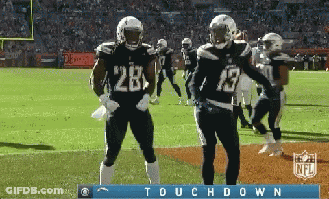 Two Football Players Wearing Number 28 And 13 Celebrate On The Field GIF