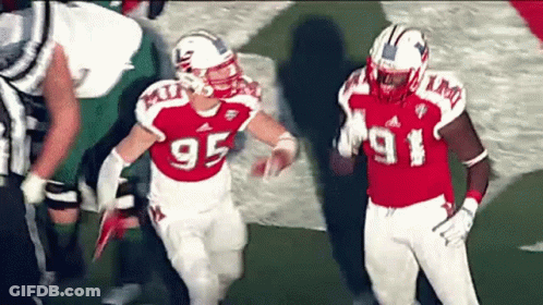 Two Football Players Wearing Red And White Uniforms With The Number 95 On Them GIF