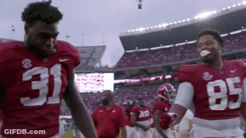 Two Football Players Wearing Red Jerseys With 31 And 95 On Them GIF