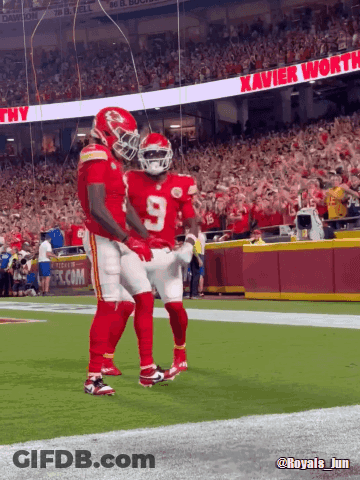 Two Football Players With Xavier Worth Banner GIF