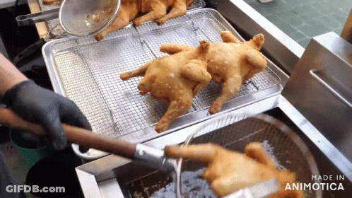Two Fried Chickens Are Being Cooked In A Fryer And The Words Made In Animatica Are Visible GIF