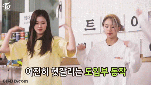 Two Girls Are Dancing In Front Of A Sign That Says ' Twice ' On It GIF