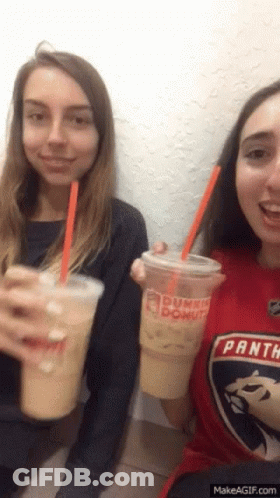 Two Girls Are Drinking Dunkin Donuts Drinks And One Has A Panthers Shirt On GIF