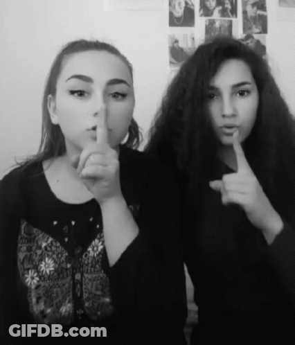 Two Girls Are Posing For A Picture And One Is Holding Her Finger To Her Lips GIF