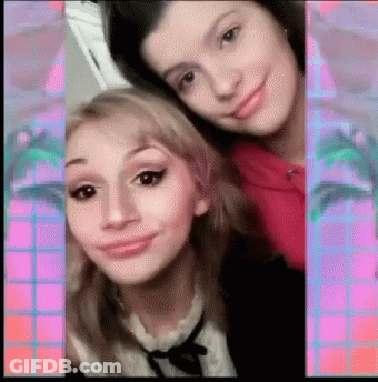 Two Girls Are Posing For A Picture And One Of Them Is Wearing A Pink Shirt GIF