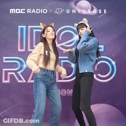 Two Girls Are Posing In Front Of A Mbc Radio X Universe Sign GIF