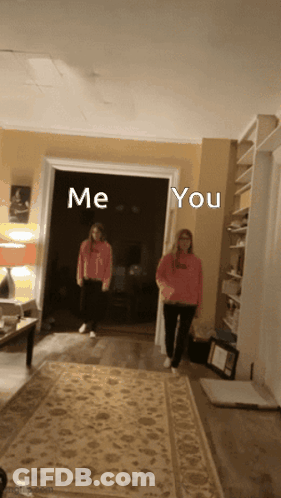 Two Girls Are Standing In A Living Room With The Words Me And You Written Above Them GIF
