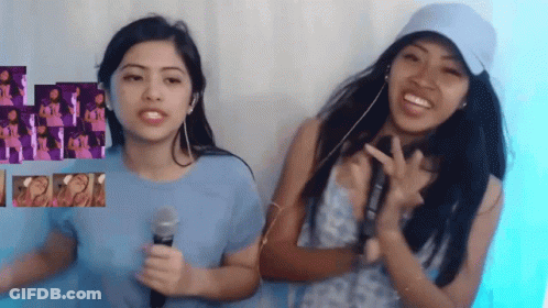 Two Girls Are Standing Next To Each Other And One Has A Microphone GIF