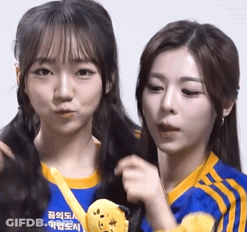 Two Girls Are Standing Next To Each Other With One Wearing A Blue Shirt That Says ' Seoul ' On It GIF
