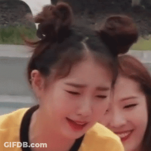 Two Girls Are Standing Next To Each Other With Their Hair In Buns And Smiling . GIF