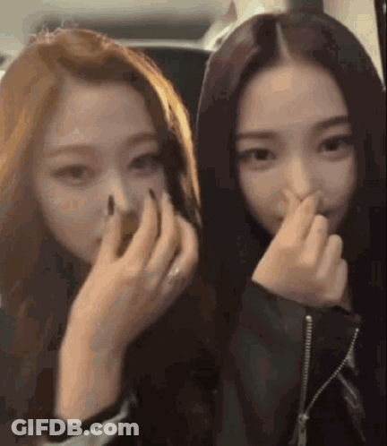 Two Girls Covering Noses GIF