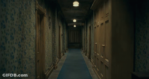 Two Girls In Blue Dresses Holding Hands In Dark Hallway GIF
