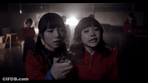 Two Girls In Red Jackets Standing In Dark Room GIF