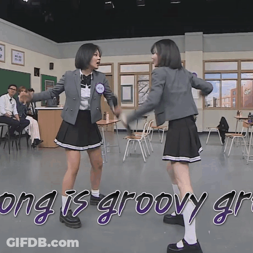 Two Girls In School Uniforms Are Dancing In A Classroom With The Words " Yung Is Groovy " Written On The Bottom GIF