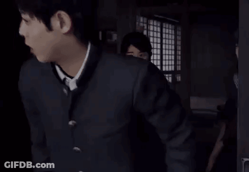 Two Girls In School Uniforms Are Standing In A Dark Room . GIF