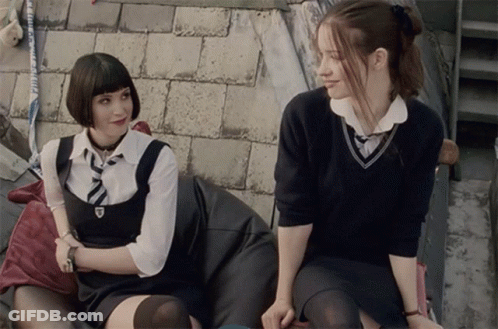 Two Girls In School Uniforms Sitting Next To Each Other GIF