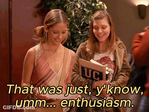 Two Girls Looking At Book With UC On Cover GIF