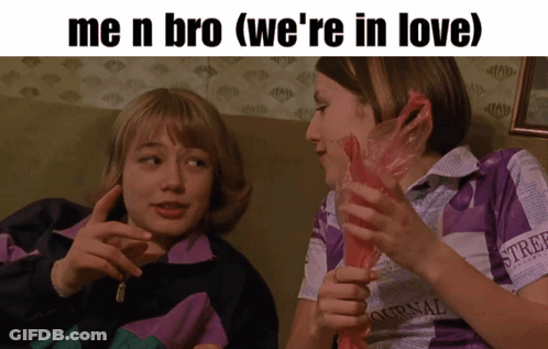 Two Girls On Couch One Wearing Ournal Shirt GIF