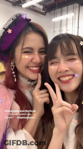 Two Girls Posing, One In Flower Hat GIF