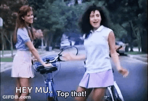 Two Girls Riding Bikes Saying Hey Mu Top That GIF