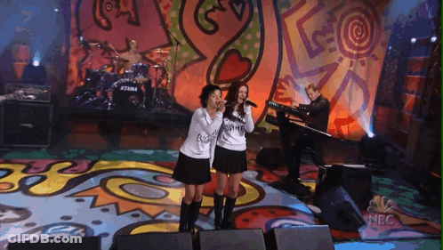 Two Girls Singing On Stage With NBC Logo GIF