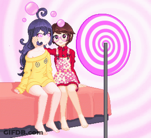 Two Girls Sit On A Bed Next To A Lollipop GIF