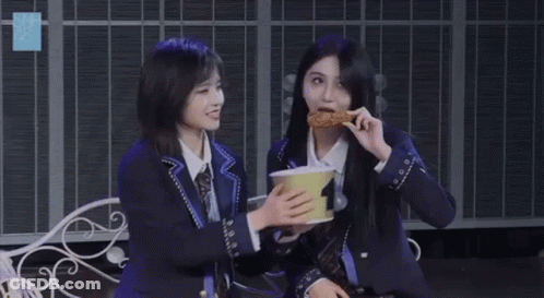 Two Girls Sitting On Bench Holding Bowl GIF