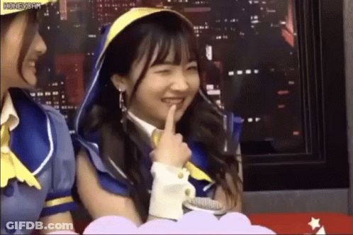 Two Girls Sitting, One Shushing GIF