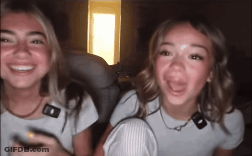Two Girls Sitting Smiling GIF