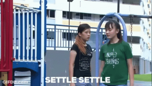 Two Girls Standing In Front Of A Playground With Settle Settle Written On The Bottom GIF
