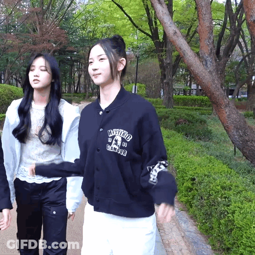 Two Girls Walking, One With Hysteria Sweatshirt GIF