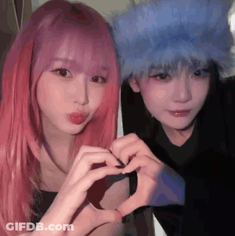 Two Girls With Pink Hair And Blue Hair Are Making A Heart Shape With Their Hands . GIF