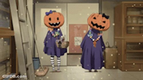 Two Girls With Pumpkins On Their Heads Stand In A Hallway GIF